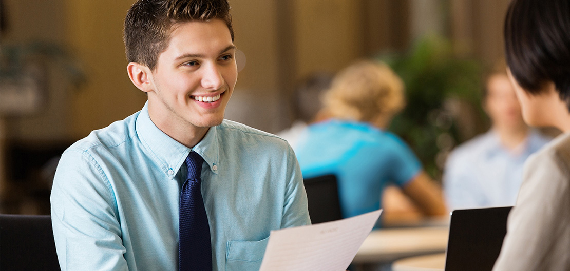 Image of smiling young man in business wear talking with woman