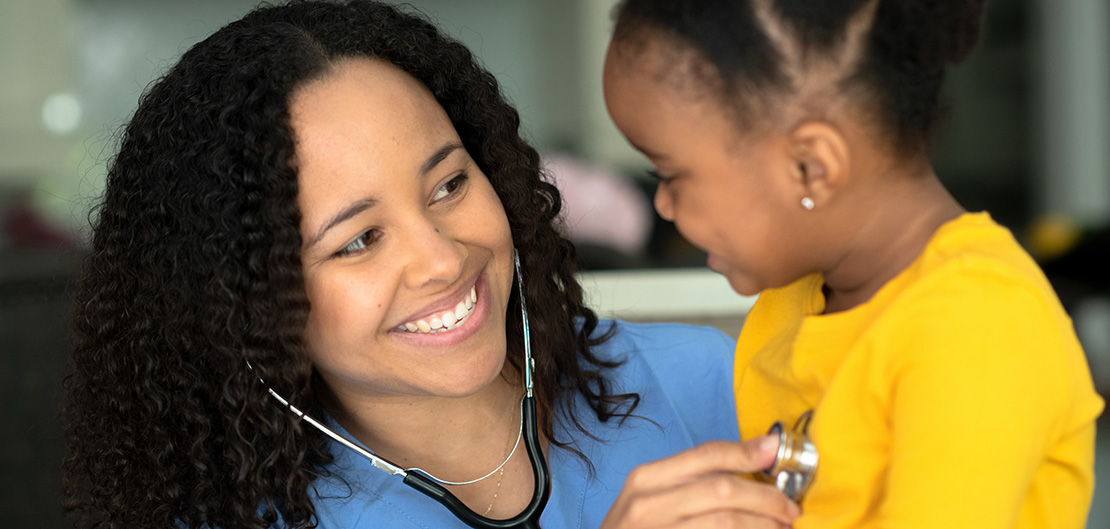 Image of nurse holding up a stethoscope to a childs chest